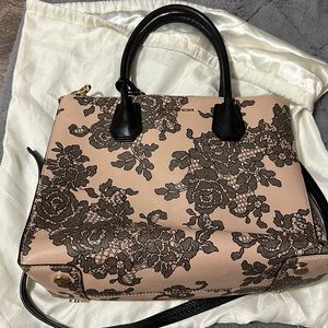 MK beige tote bag with black lace floral pattern